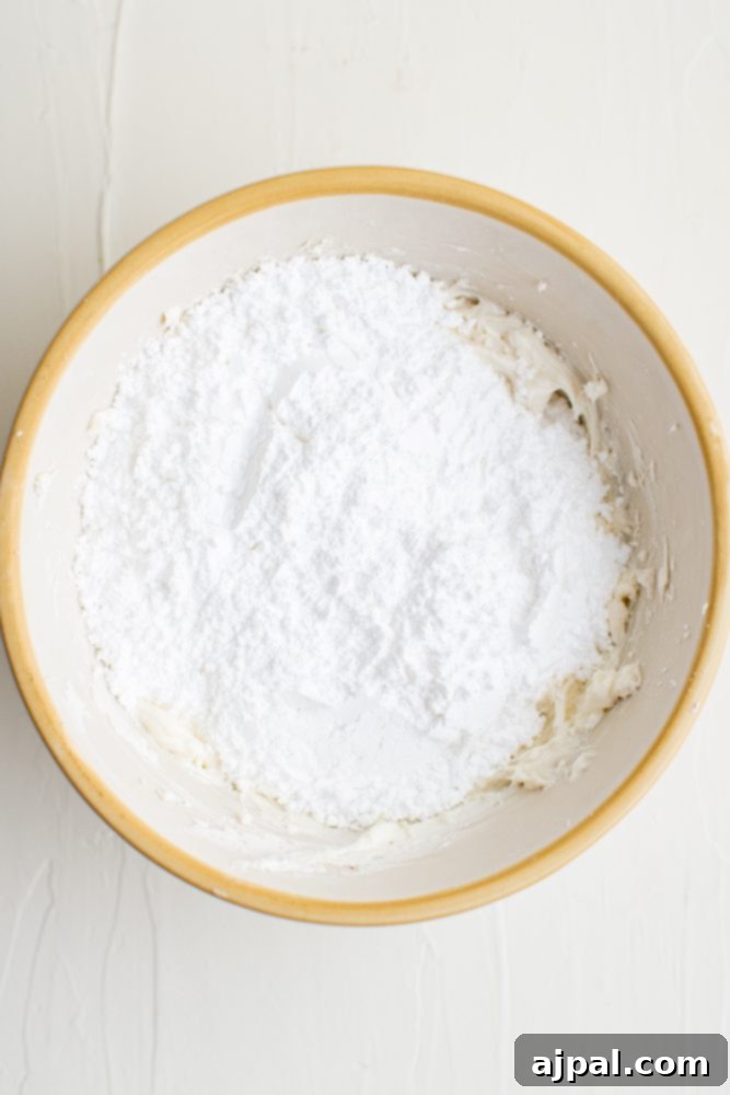 Effortless Fruit Pizza Perfection 11 A bowl of fine powdered sugar, sifted and ready to be incorporated into the creamy fruit pizza topping.