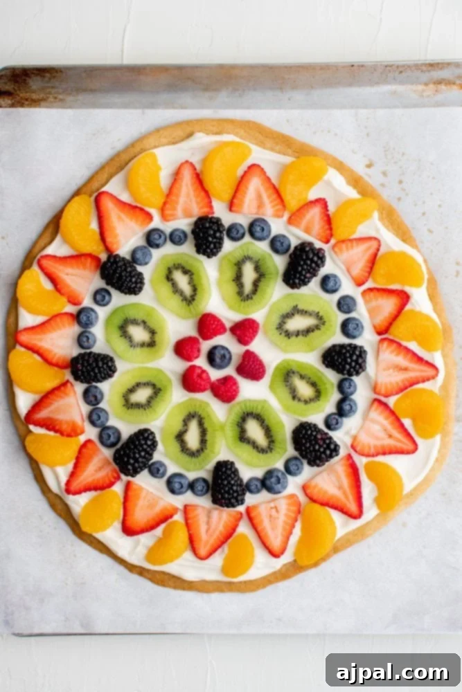 Effortless Rainbow Fruit Pizza 15 Various colorful fresh fruits like blueberries, raspberries, kiwis, and oranges beautifully arranged on a creamy fruit pizza.
