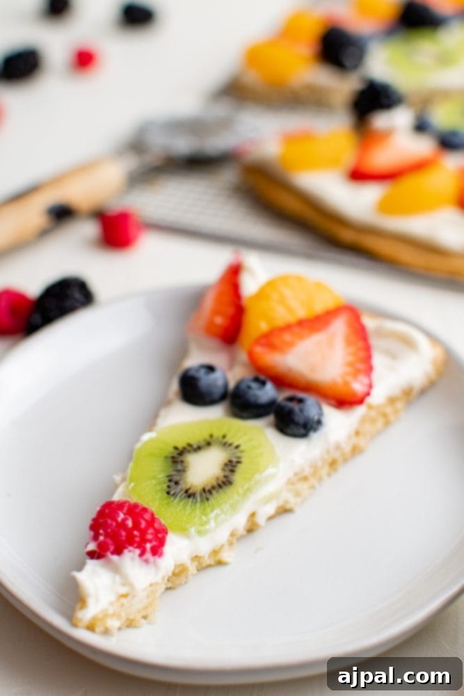 Effortless Fruit Pizza Perfection 18 A single, delectable slice of fruit pizza, showcasing the colorful fruit, creamy topping, and crisp cookie crust.