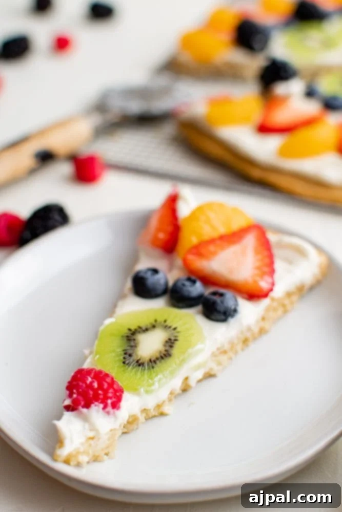Effortless Rainbow Fruit Pizza 17 A delectable slice of fruit pizza, perfectly portioned to show off its vibrant toppings and inviting layers.