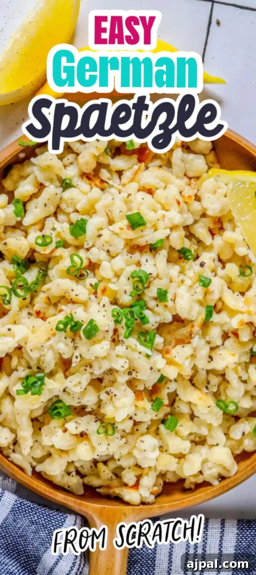 A serving of golden-brown Spaetzle noodles arranged on a wooden plate, seasoned with fresh black pepper and sliced green onions, accompanied by a bright lemon wedge.