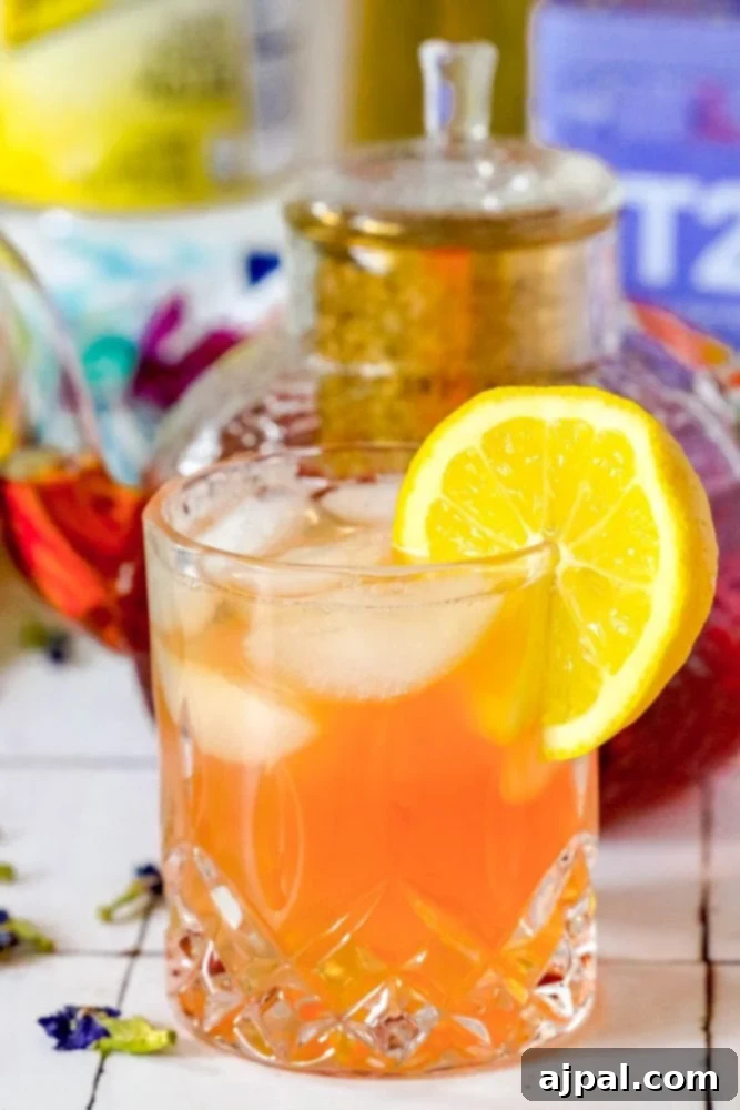 Sparkling Earl Grey Tonic Recipe 2 A beautifully set scene featuring a teapot and a cocktail glass, with T2 and Schweppes brands subtly visible in the background, suggesting the ingredients for a delicious sparkling tea and tonic mocktail.