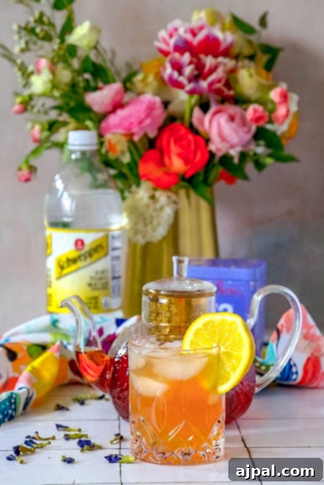 Bubbly Earl Grey Tea Tonic 6 A beautiful Earl Grey Sparkling Tea and Tonic Mocktail in a glass, with a lemon slice and a sparkling background.