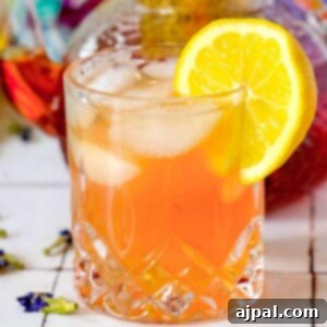 A glass of sparkling tea and tonic with a hint of Earl Grey, garnished with a slice of lemon.