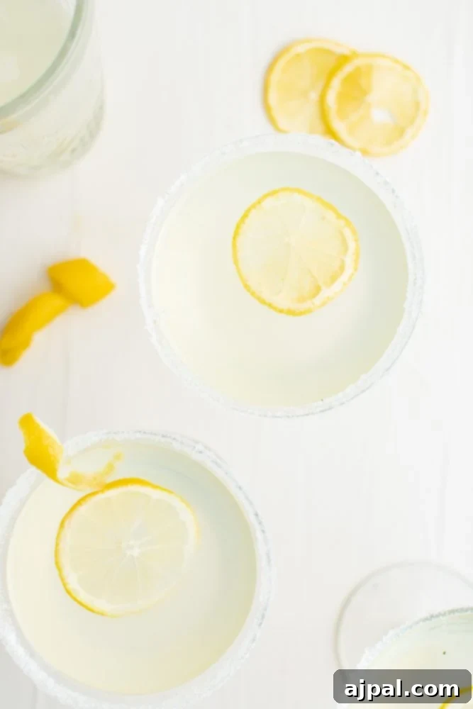 Four martini glasses filled with the refreshing lemon drop cocktail, adorned with fresh lemon slices, ready for a delightful toast.