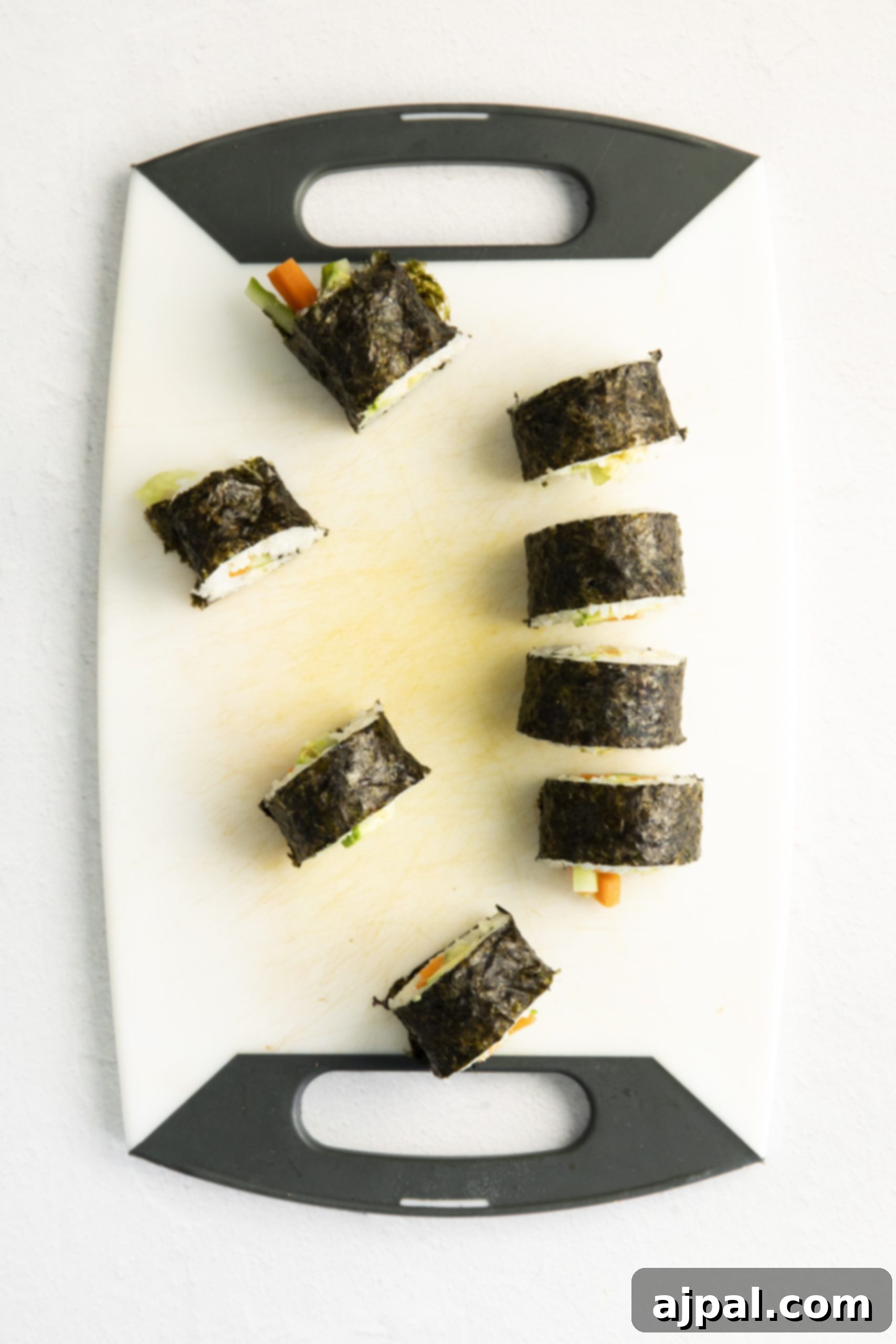 Effortless Vegan Sushi Rolls 12 Vegan sushi rolls on a white background.