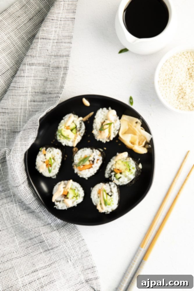 Beautifully arranged Japanese vegan sushi on a black plate with chopsticks, highlighting the fresh ingredients and vibrant colors.