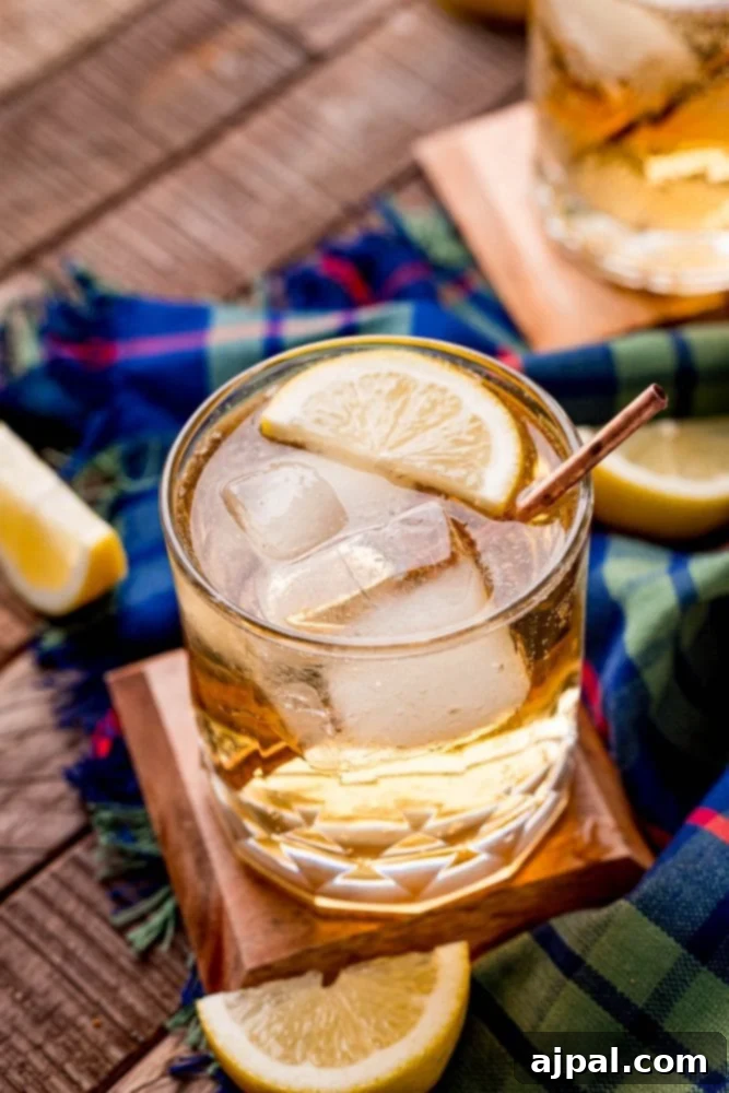 A glass of Scotch and Soda with a slice of lemon and ice, ready to be enjoyed.