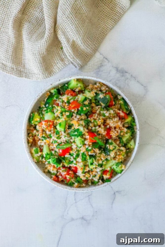 A bowl of easy tabbouleh recipe couscous salad on a marble table.