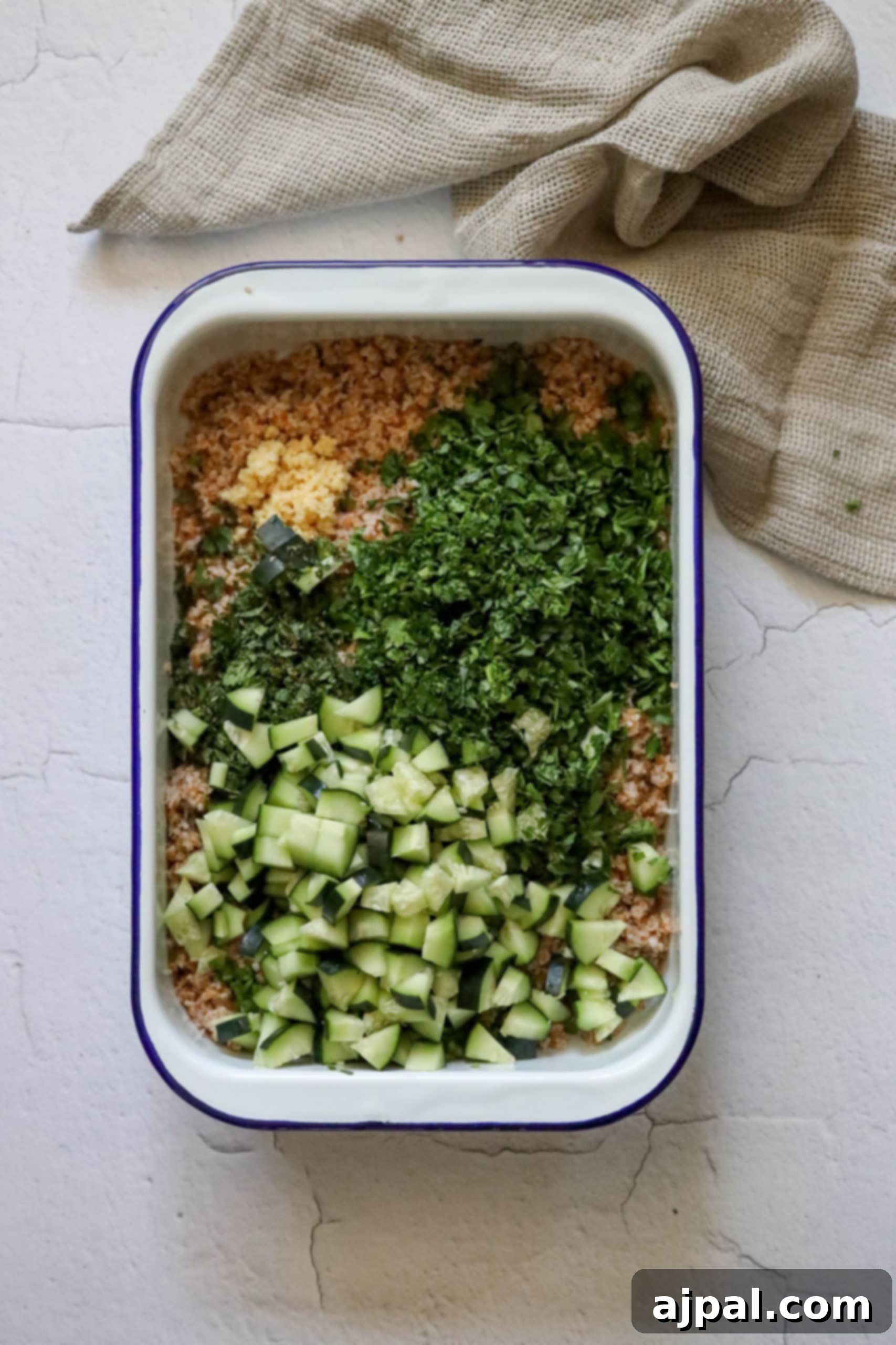Picture of bulgur with parsley, mint, green onion, garlic, and cucumbers, showing the addition of fresh vegetables.