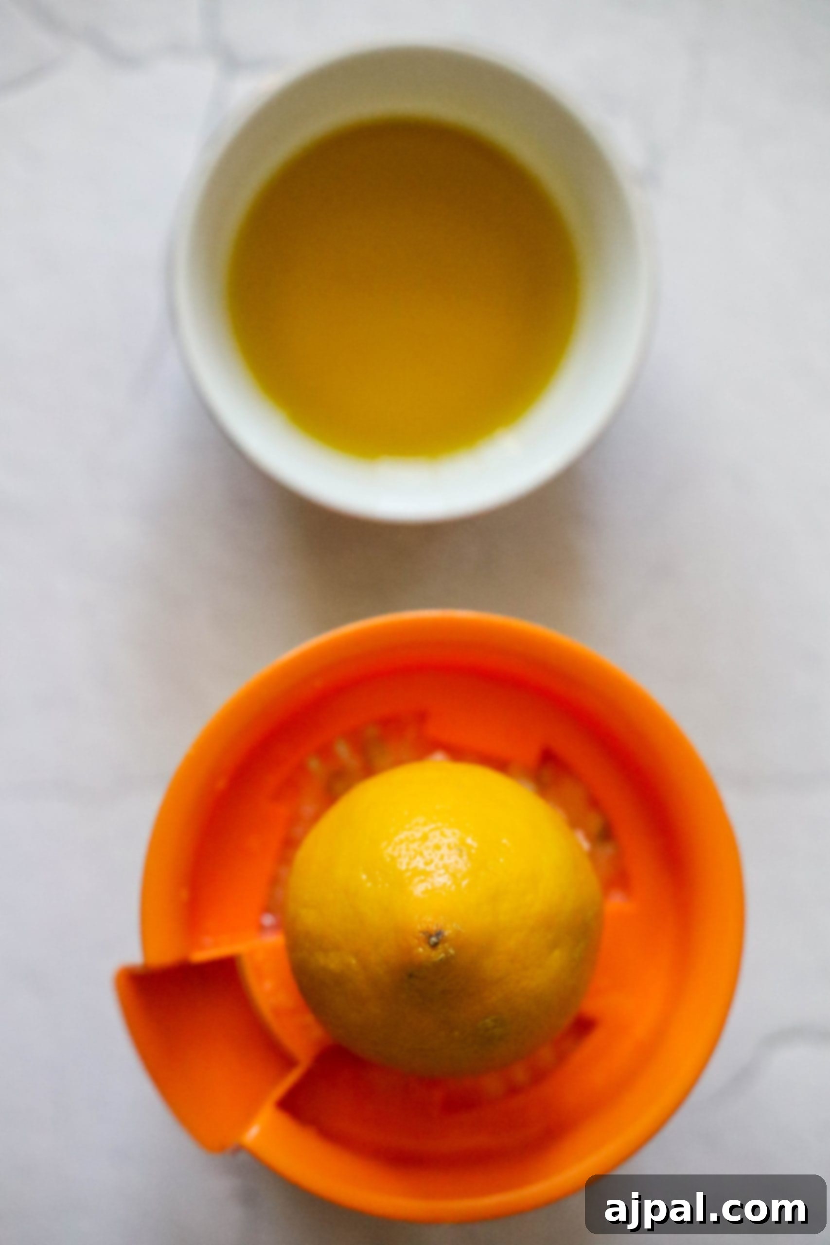 picture of lemon half on a juicer with a bowl of olive oil