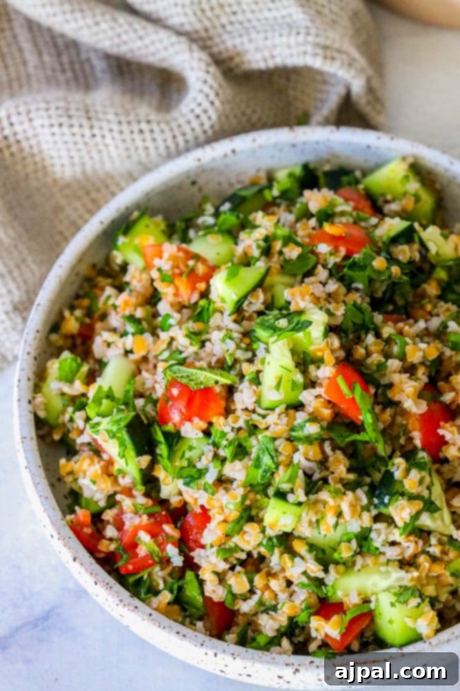 Picture of tabbouleh in a dish, perfectly mixed with tomatoes and cucumbers, ready for serving.