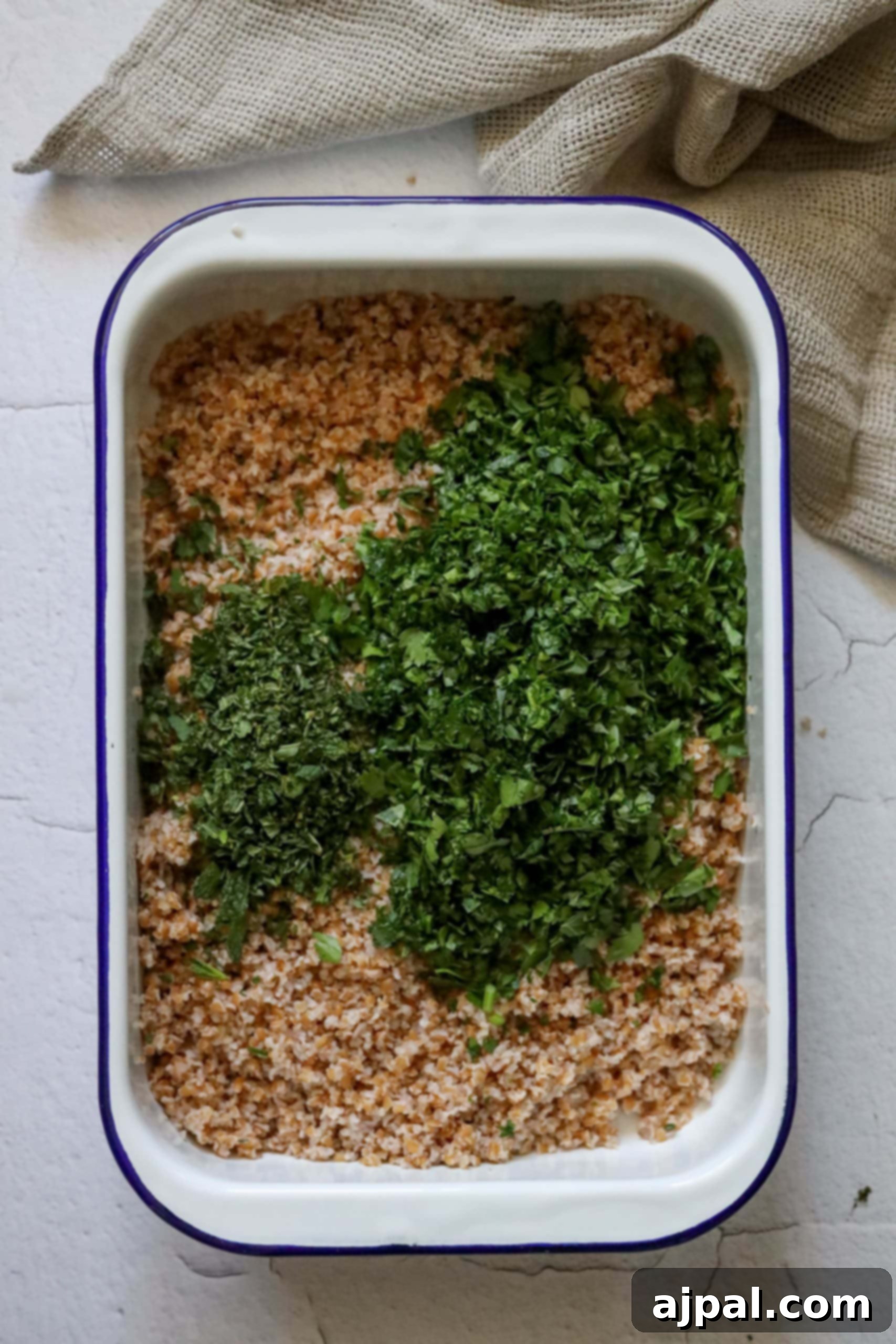 Picture of bulgur with finely minced parsley and mint, showing the initial mixing stage.