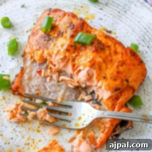 A plate showcasing air-fried jerk salmon with a fork, ready to be enjoyed.