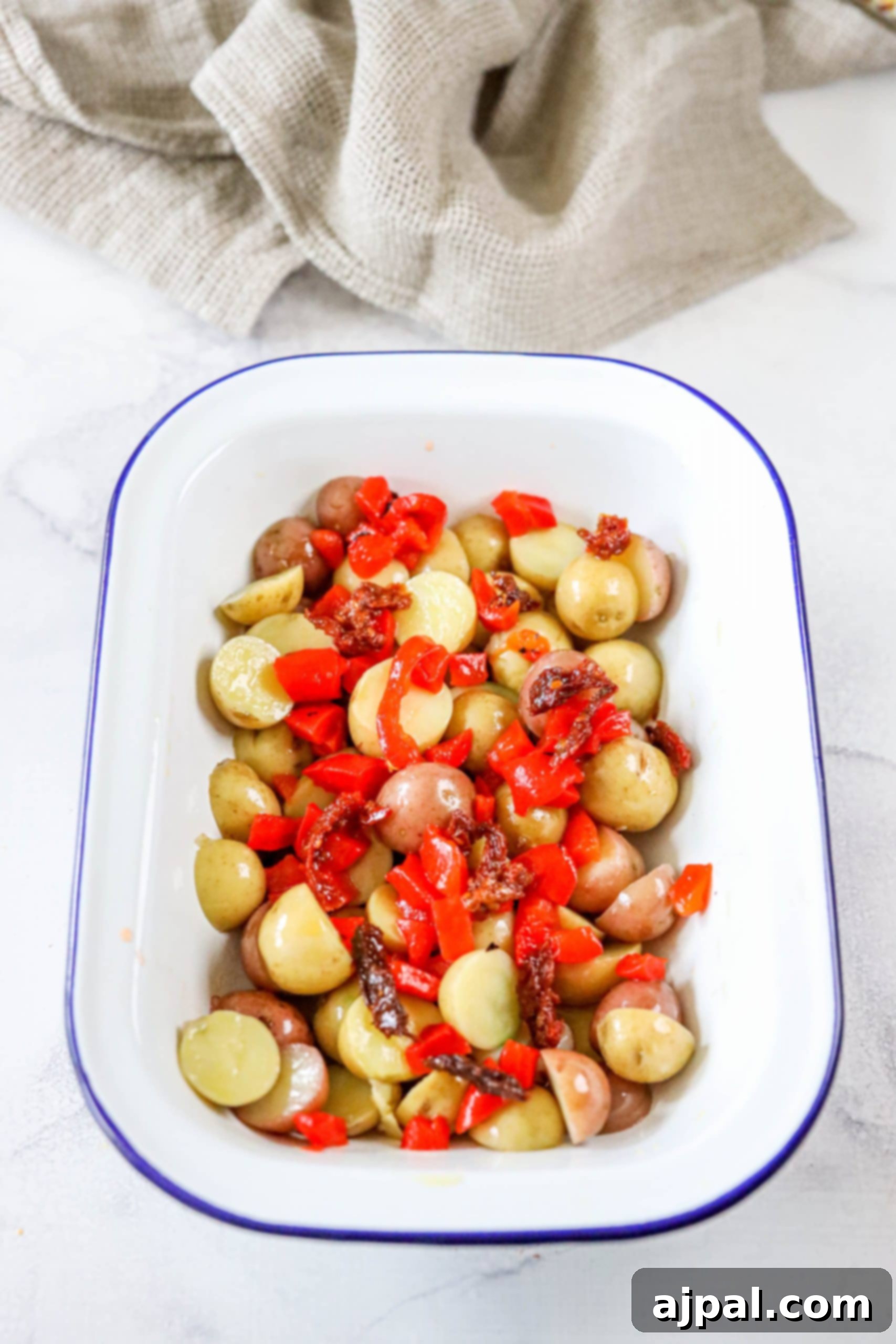 Zesty Italian Potato Salad 6 A close-up of tender potatoes and vibrant red pepper strips, beautifully arranged on a platter for an Italian Potato Salad.