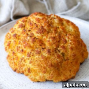 A whole roasted cauliflower on a plate with a napkin.