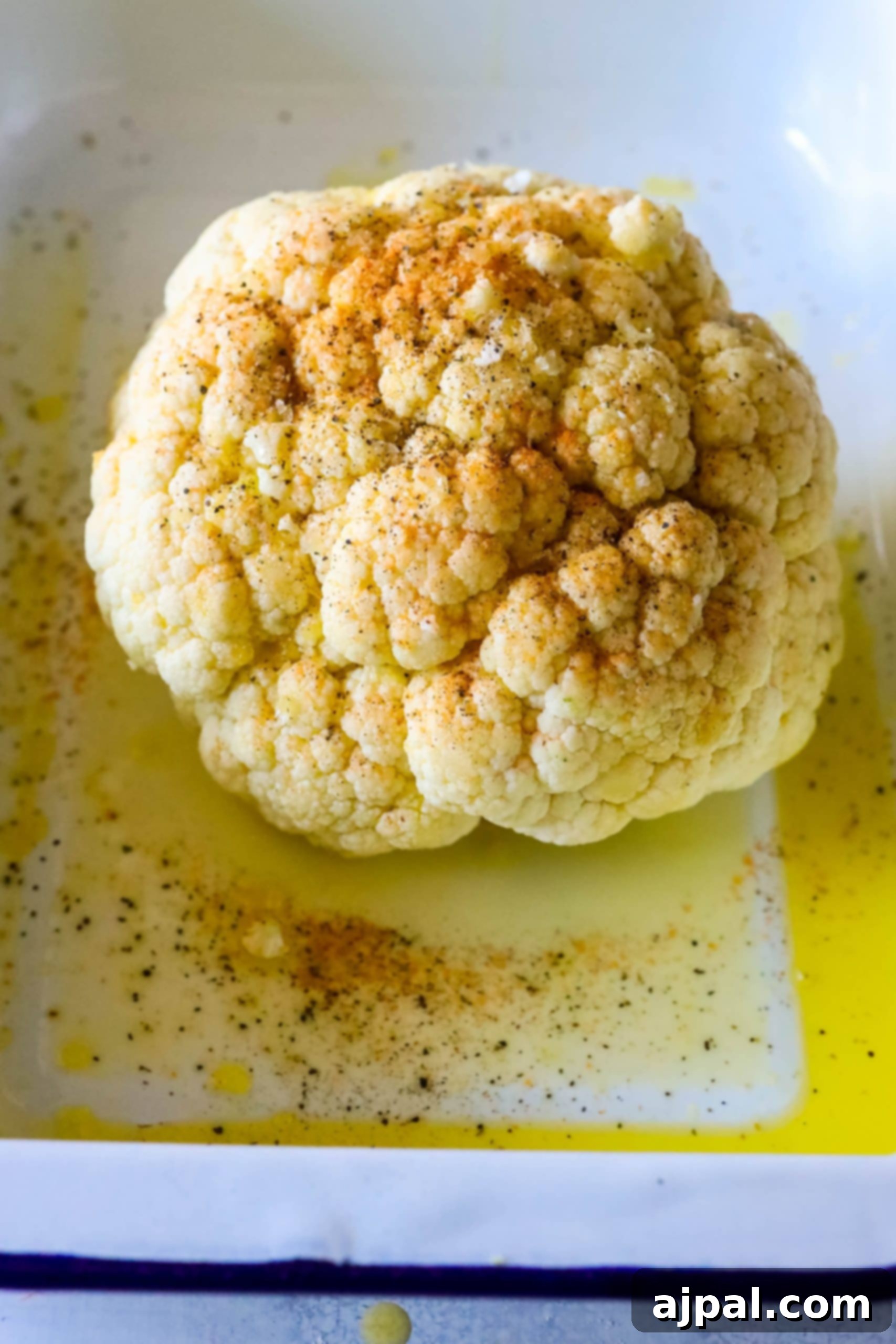 A whole roasted cauliflower with spices on it.