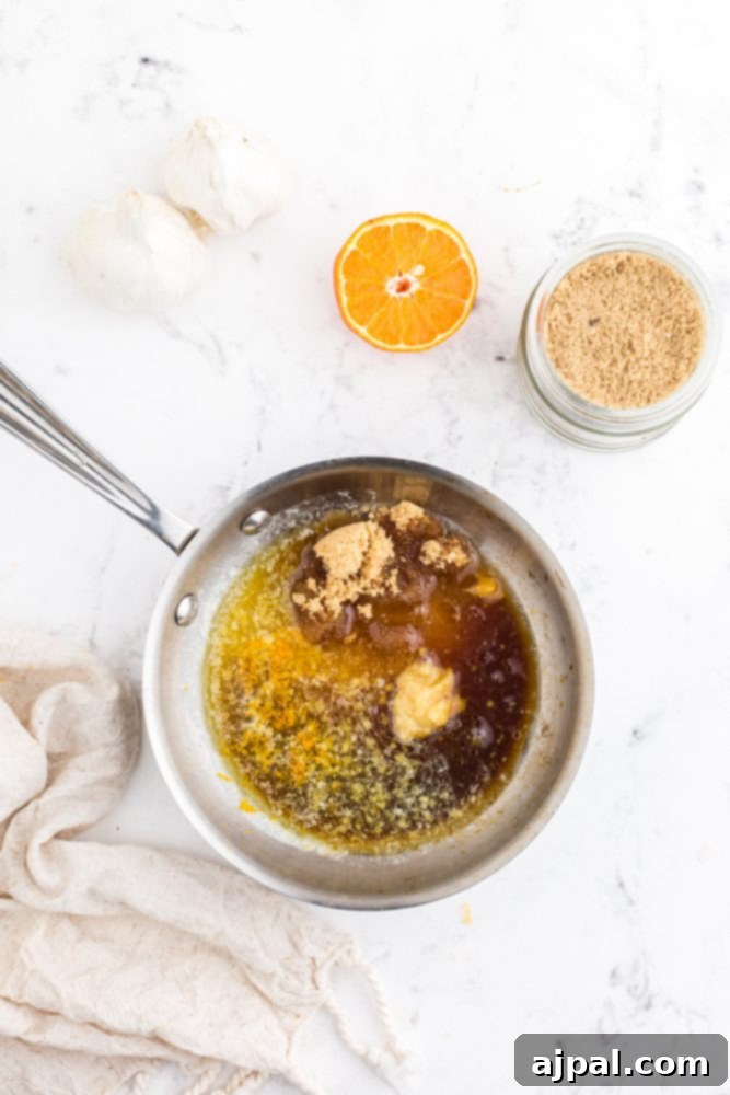 All the orange glaze ingredients – ginger paste, orange zest, orange juice, brown sugar, and soy sauce – combined in a pan, simmering to perfection.
