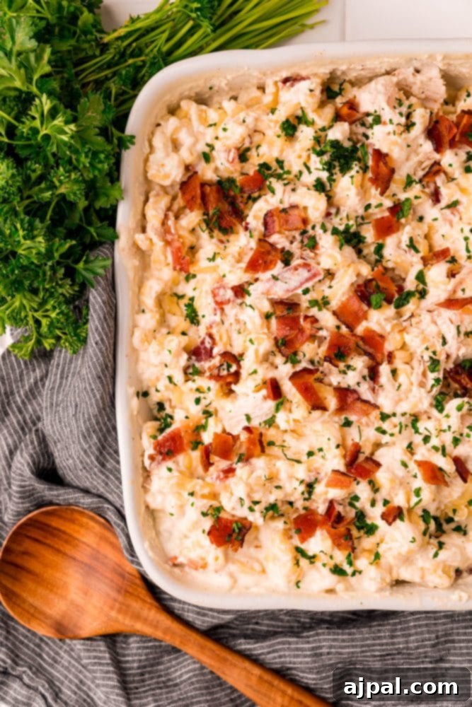 Loaded Bacon Ranch Chicken Mac and Cheese 2 Creamy pasta with chicken, crispy bacon, and fresh herbs in a serving bowl, showcasing a rich and inviting texture.
