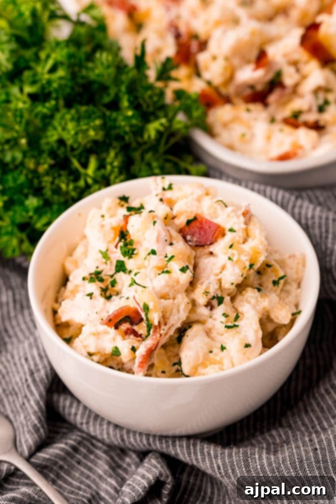 Loaded Bacon Ranch Chicken Mac and Cheese 11 A serving of creamy pasta with chicken, bacon, and herbs in a white bowl, ready to eat and garnished with fresh parsley.