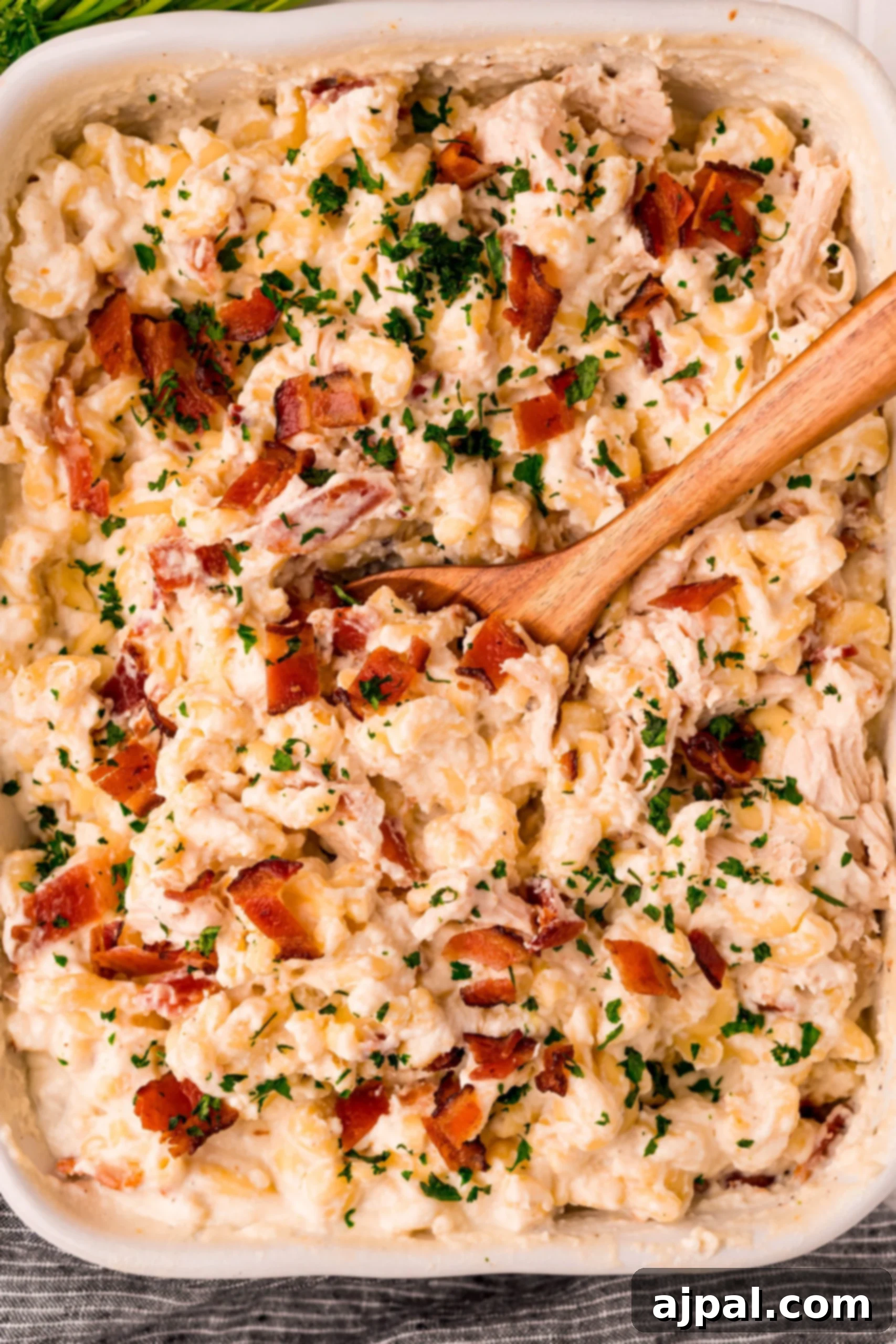 Loaded Bacon Ranch Chicken Mac and Cheese 9 A freshly baked dish of bacon chicken ranch macaroni and cheese, garnished with fresh parsley and extra bacon bits, ready to serve and impress.