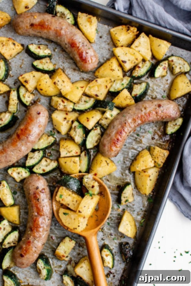 Simple Sheet Pan Sausage Dinner 2 Picture of sausage, potatoes, and zucchini baking on a sheet pan, ready to be served as an easy one-pan dinner.