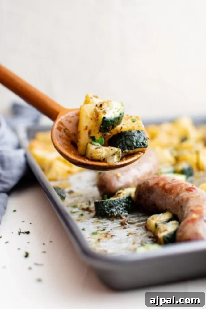 Simple Sheet Pan Sausage Dinner 10 Picture of a fully baked sheet pan sausage bake with potatoes and zucchini, golden and ready to serve.