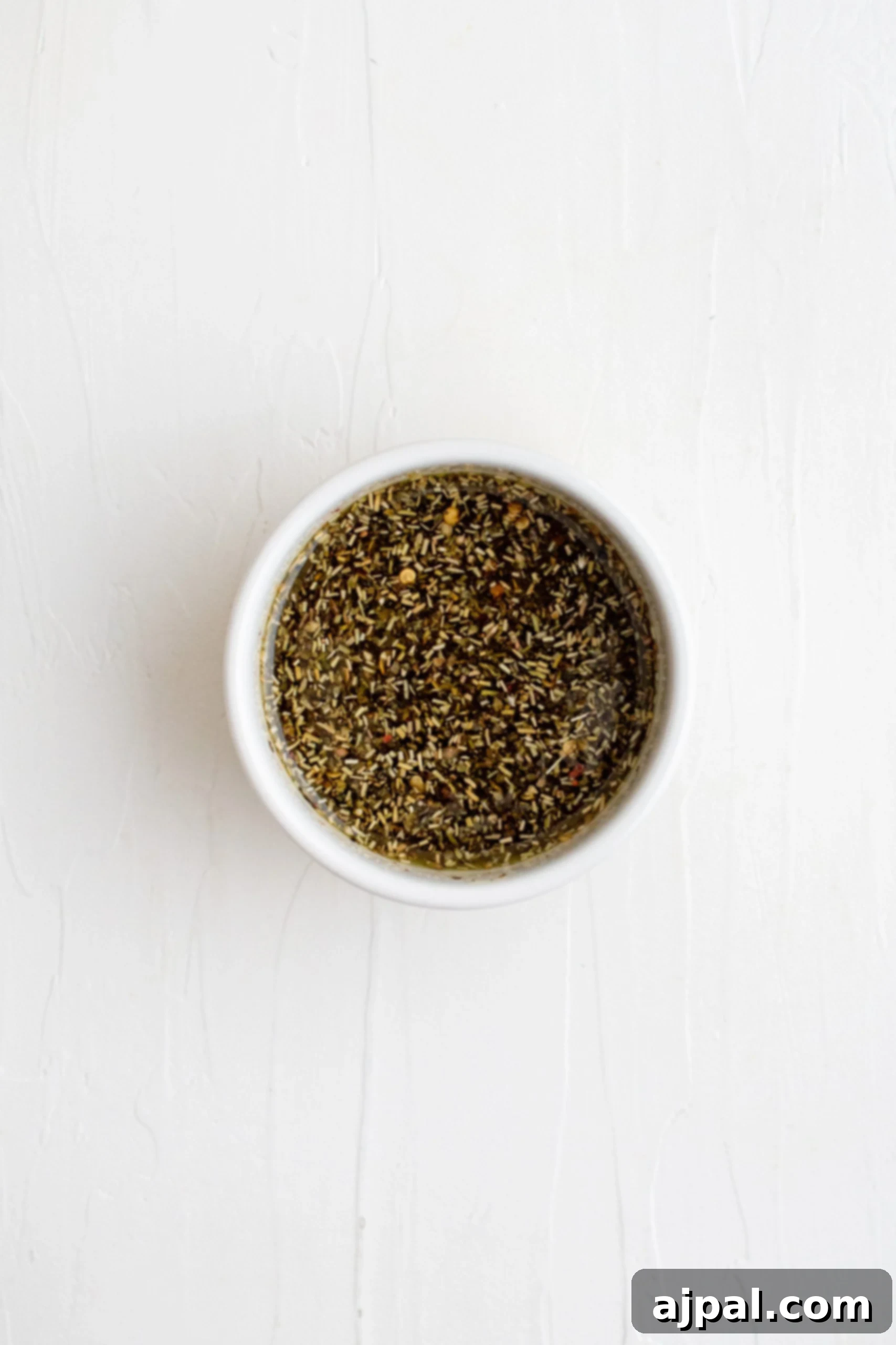 Simple Sheet Pan Sausage Dinner 12 Picture of herbs mixed in a bowl, showcasing the aromatic seasoning for the bake.