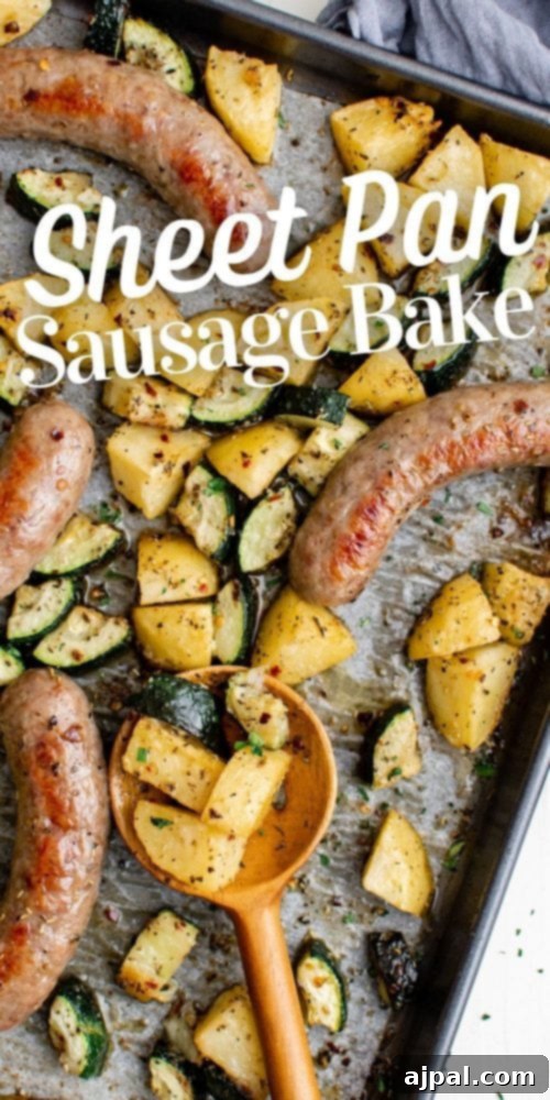 Simple Sheet Pan Sausage Dinner 19 Picture of a large sheet pan with the finished sausage, potatoes, and zucchini bake, with a serving spoon ready.