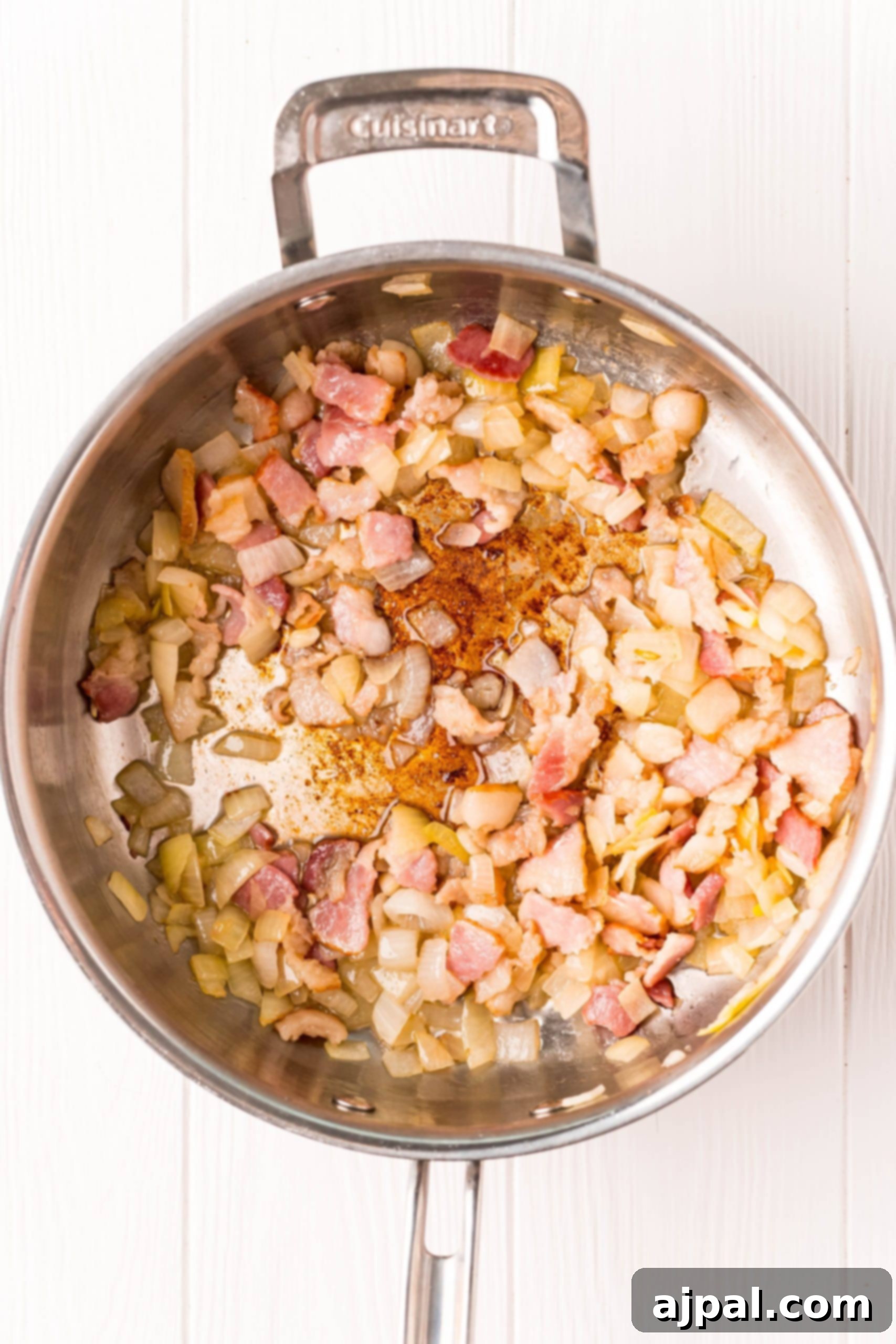 Ham and onions sizzling in a pan, a key step in preparing a delicious slow cooker recipe.
