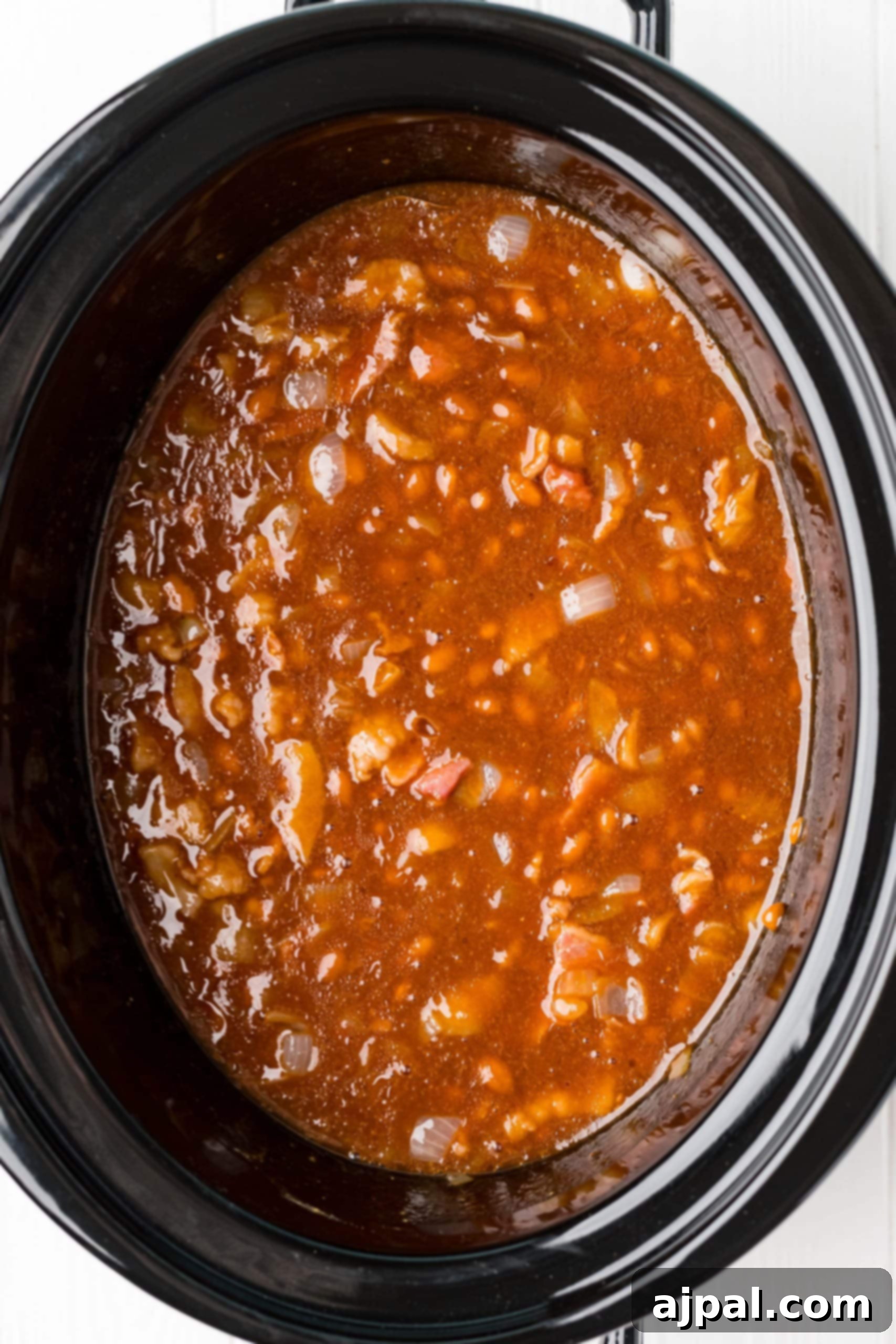 A slow cooker brimming with chili and beans, capturing the hearty essence of comfort food.
