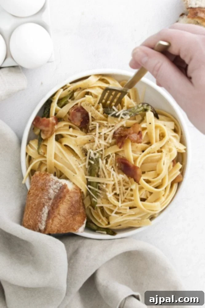Asparagus Carbonara with Roasted Flair 5 A rustic bowl brimming with Roasted Asparagus Carbonara, featuring a medley of pasta, crispy bacon, tender asparagus spears, and a rich, creamy sauce, all ready to be enjoyed.
