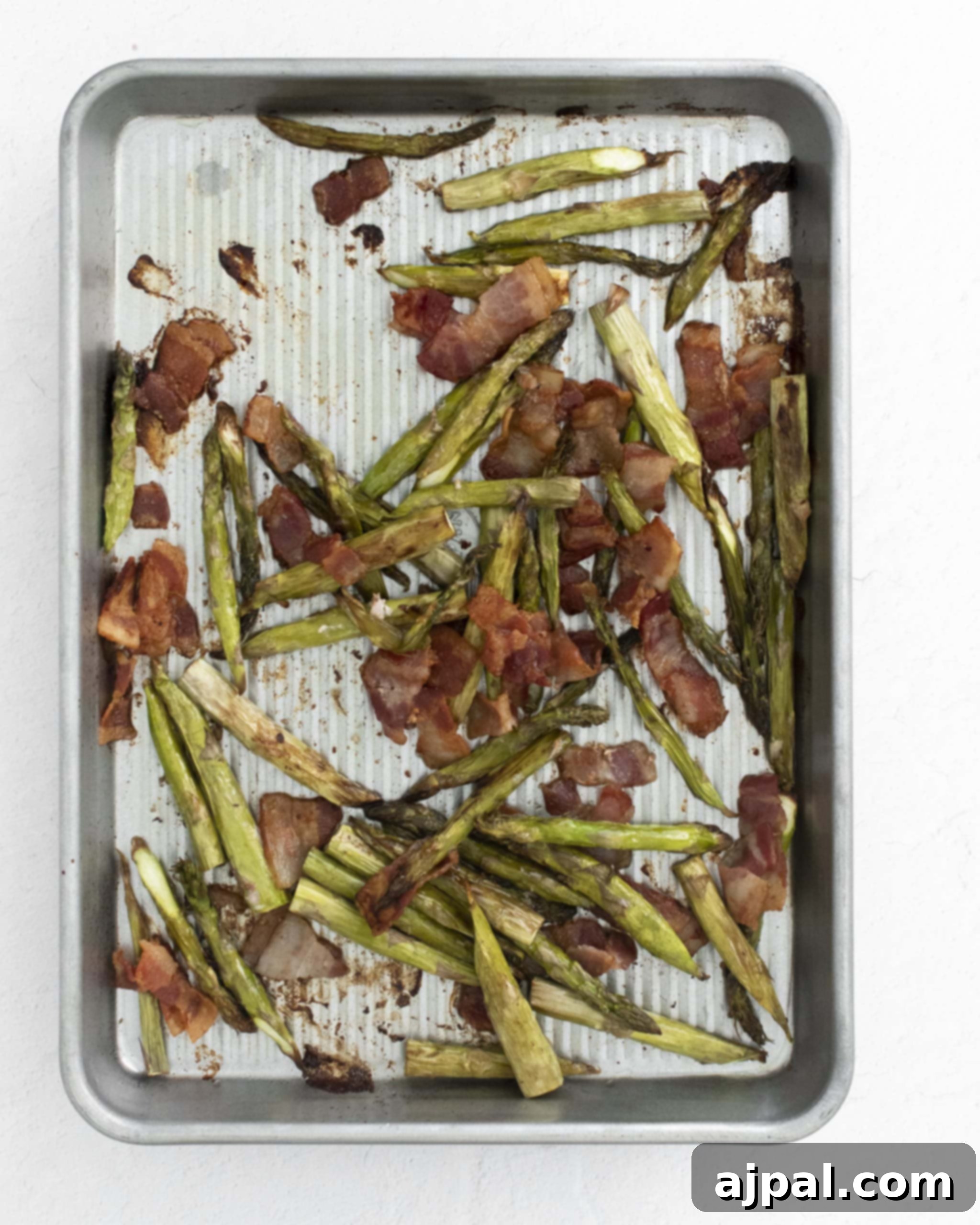 Asparagus Carbonara with Roasted Flair 9 picture of cooked crispy bacon and tender roasted asparagus on a baking dish