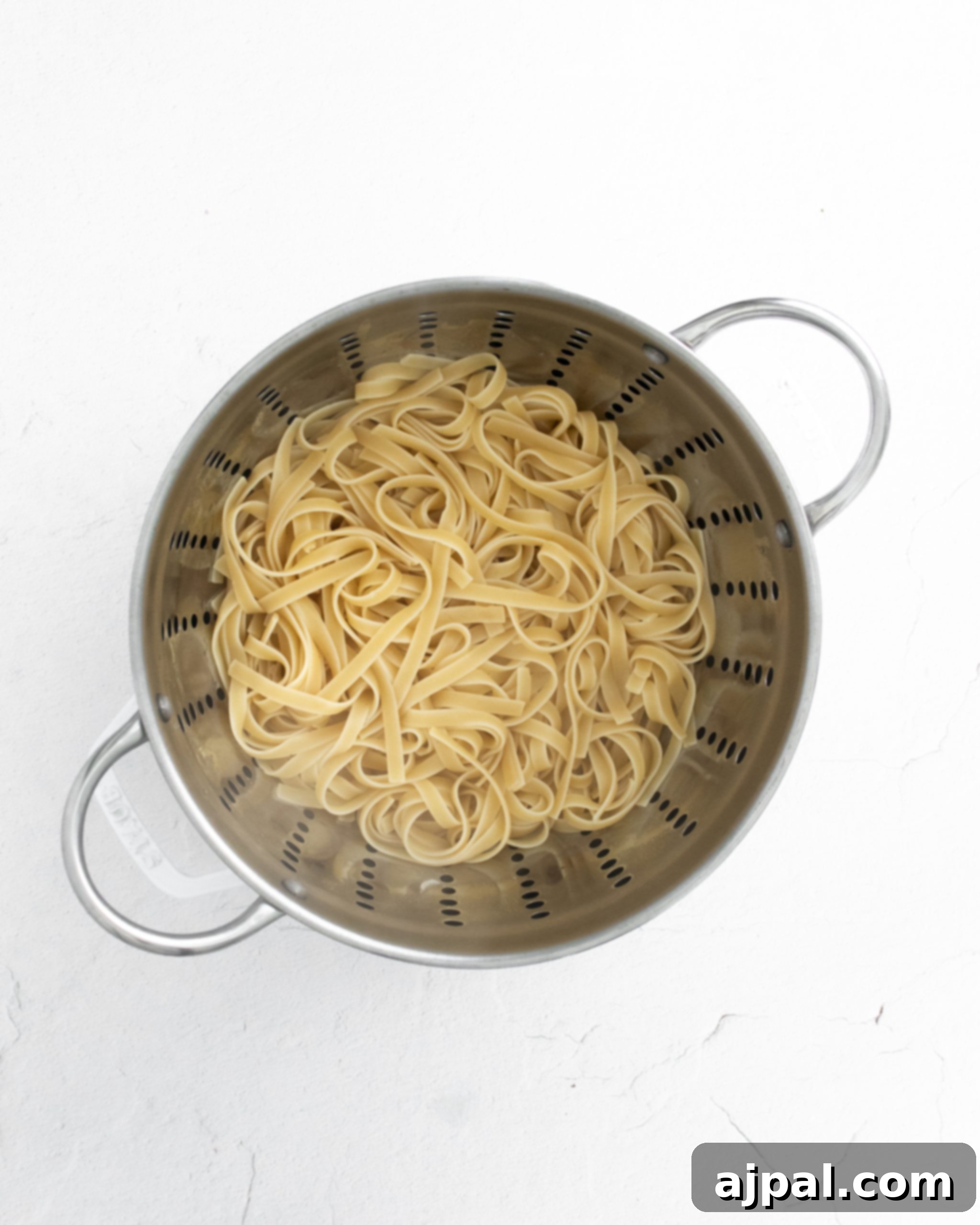 Asparagus Carbonara with Roasted Flair 10 picture of cooked fettuccine noodles in a colander, ready to be sauced