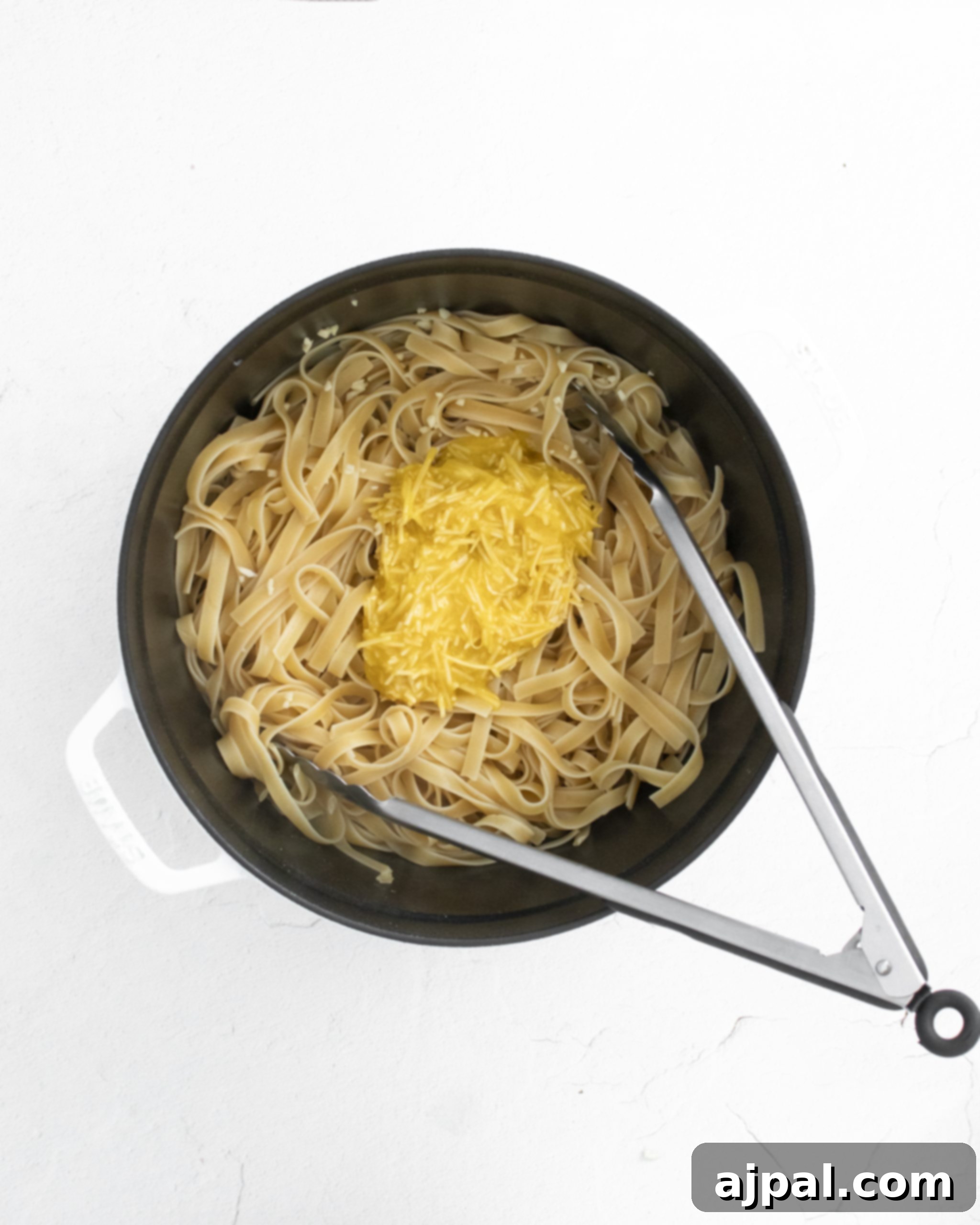 Asparagus Carbonara with Roasted Flair 11 picture of carbonara sauce being poured onto cooked pasta noodles in a pot