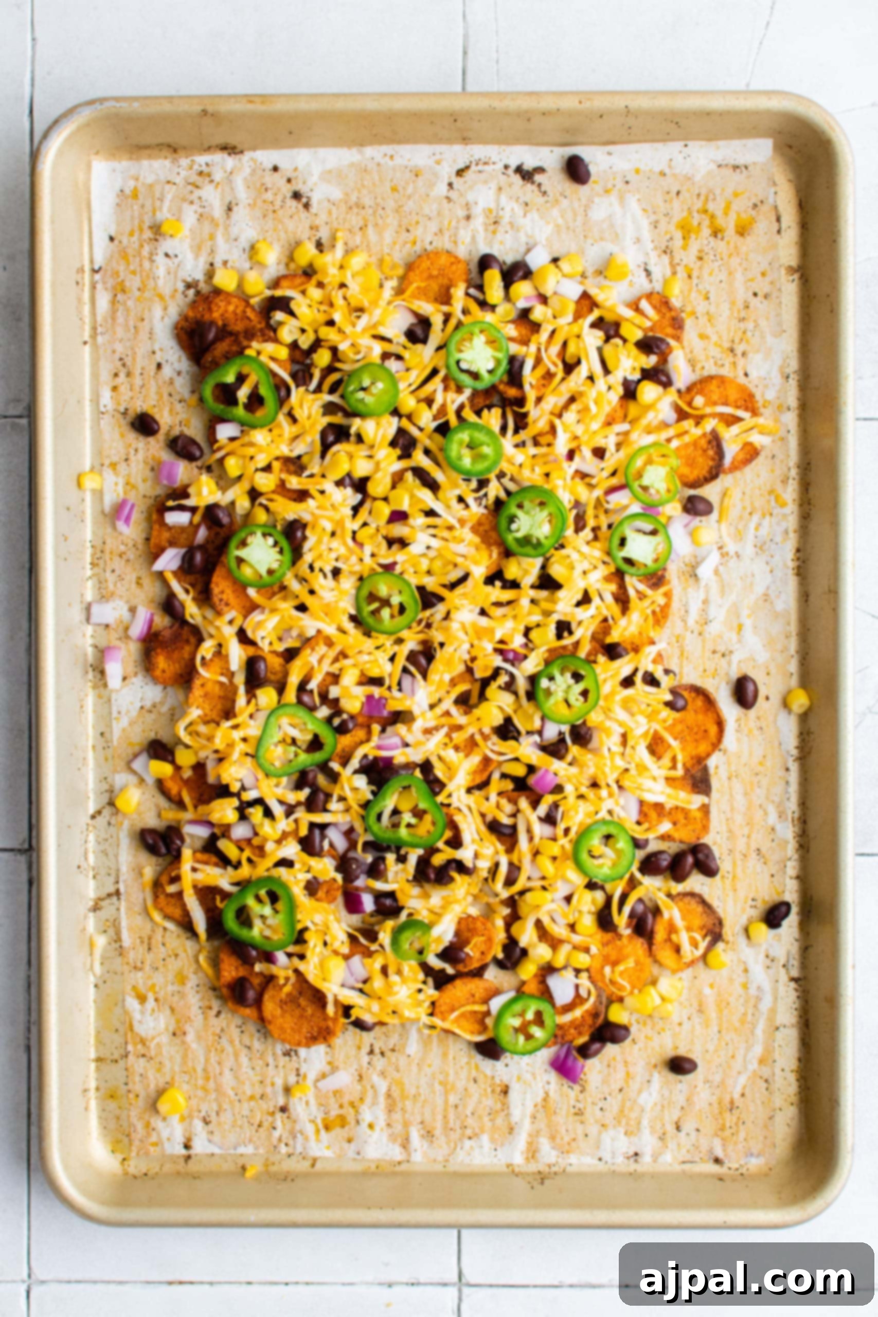 Cheesy vegetarian sweet potato nachos, fresh from the oven, with perfectly melted and slightly browned cheese.