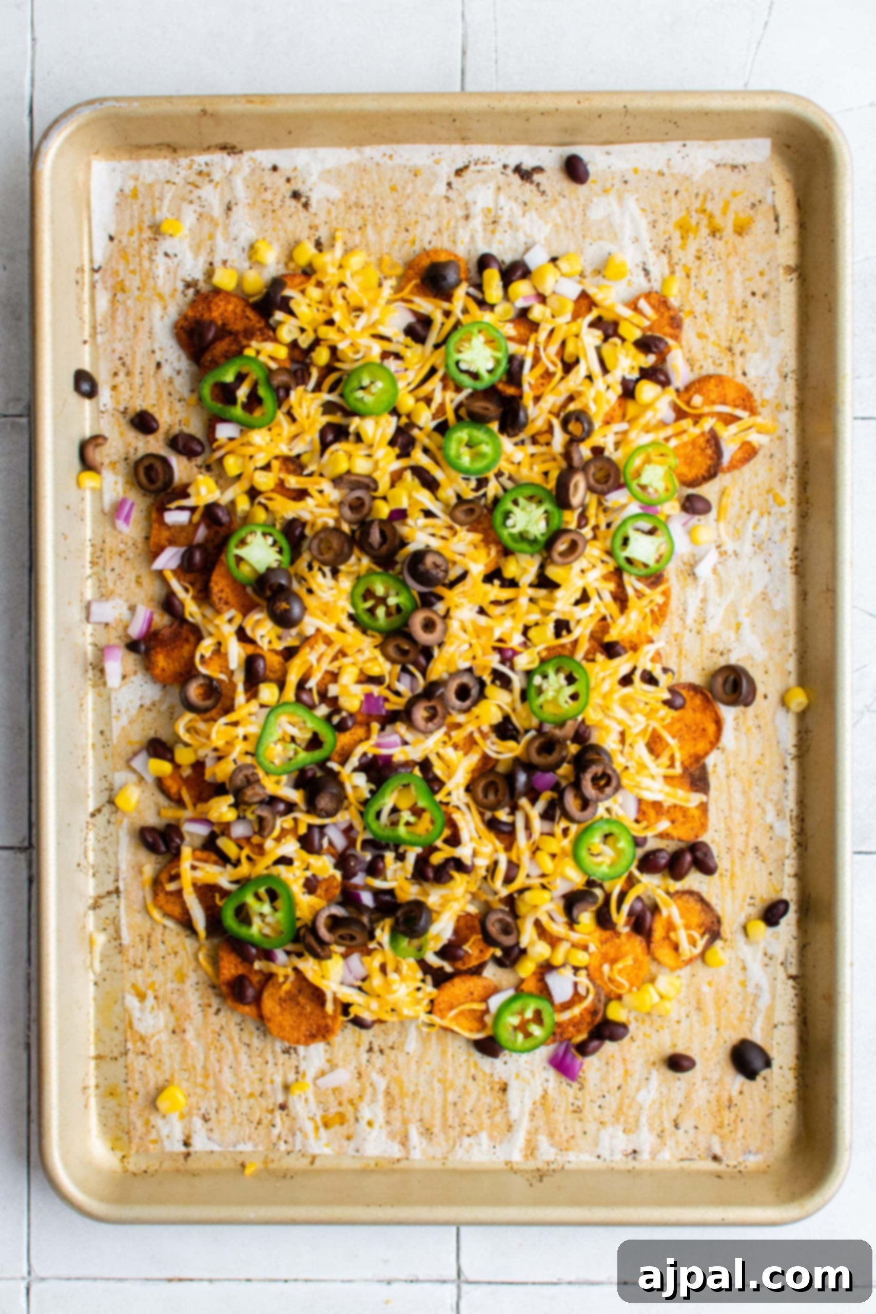 The full sheet pan of easy vegetarian sweet potato nachos, beautifully baked and ready for the final fresh garnishes.