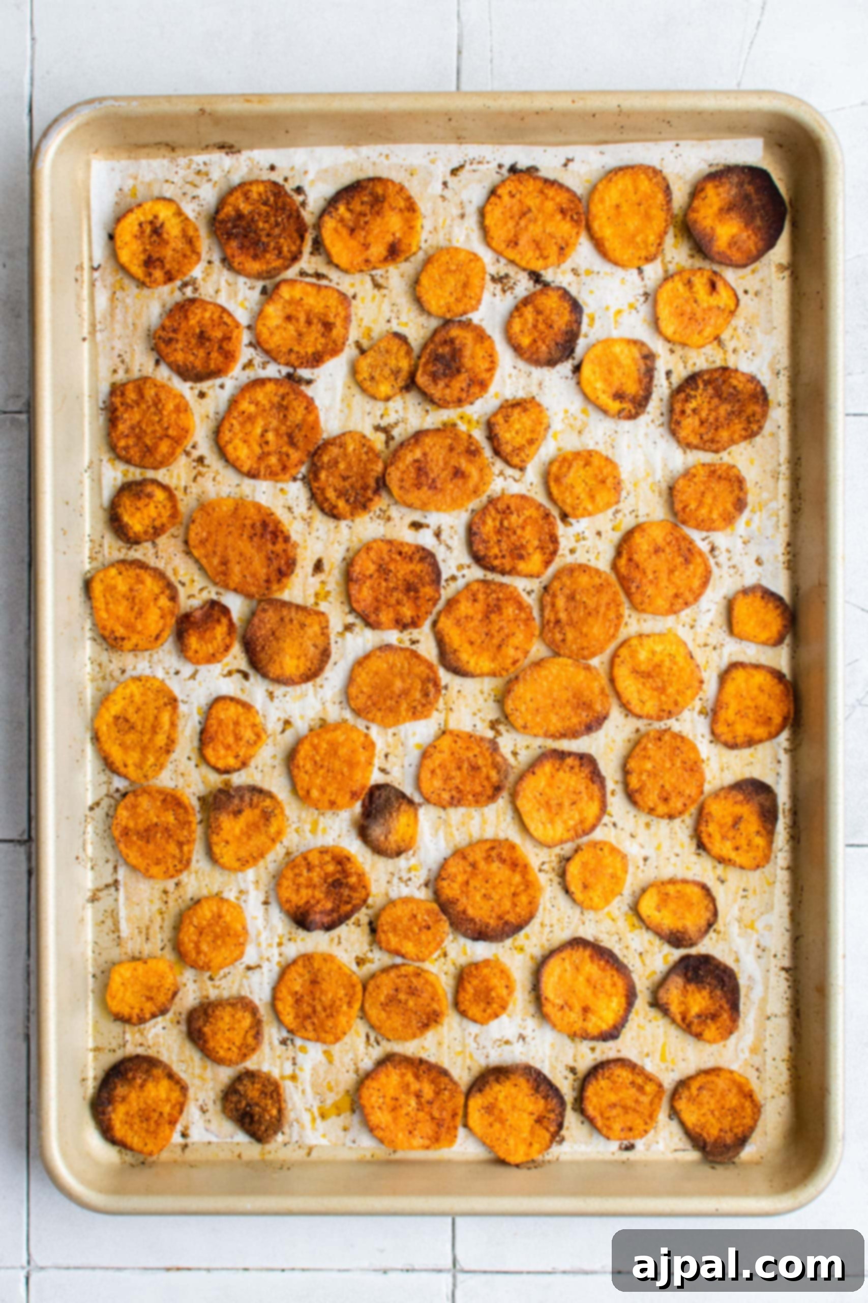 Baked sweet potato fries on a sheet, showcasing their golden crispiness and vibrant color.