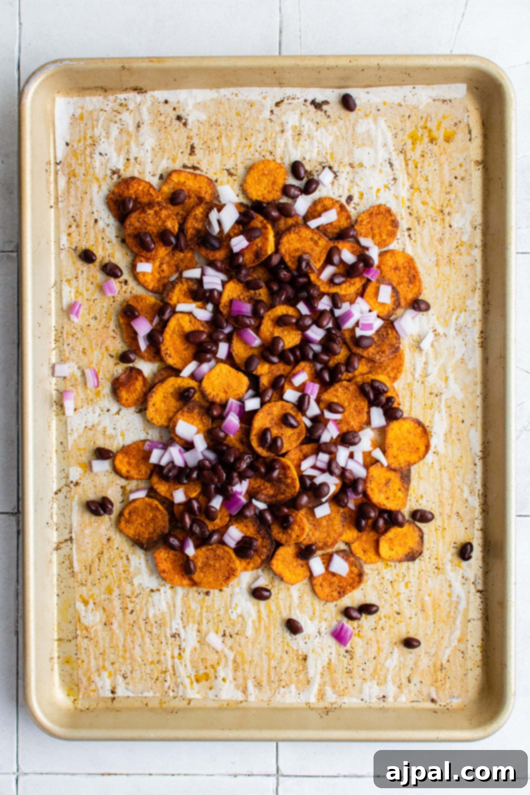 Baked sweet potato chips on a sheet, showcasing their crisp texture before adding toppings.