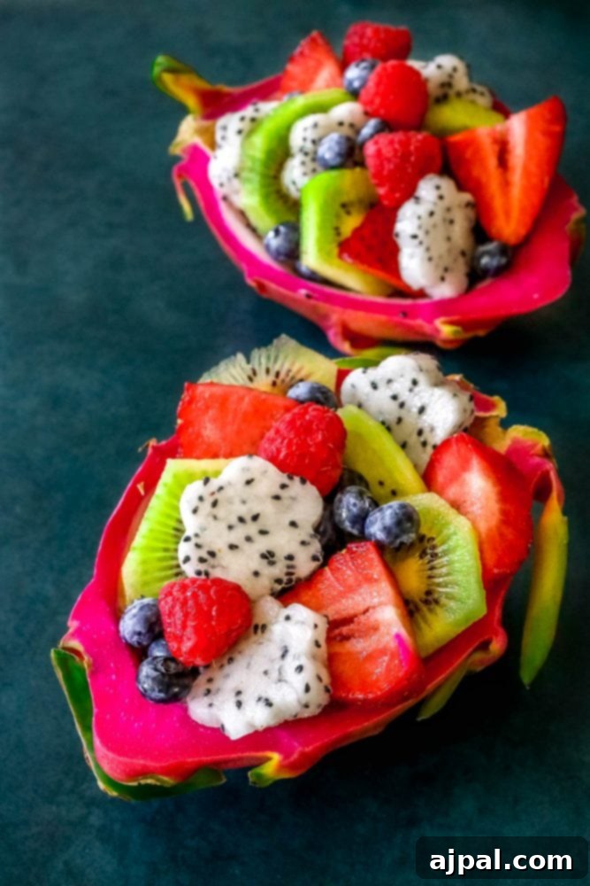 Tropical Dragon Fruit Salad 2 Picture of diced fruit salad in a carved out dragon fruit hull, brimming with colorful berries and exotic fruits.