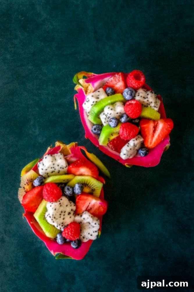 Tropical Dragon Fruit Salad 6 Picture of two whole dragon fruits on a dark background, showcasing their vibrant colors and unique texture, ready for a fruit salad.