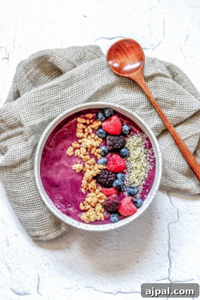 Triple Berry Smoothie Bowls 2 A beautifully arranged berry smoothie bowl, topped with fresh raspberries, crunchy granola, succulent blackberries, plump blueberries, and nutritious hemp hearts. A perfect, healthy breakfast option.