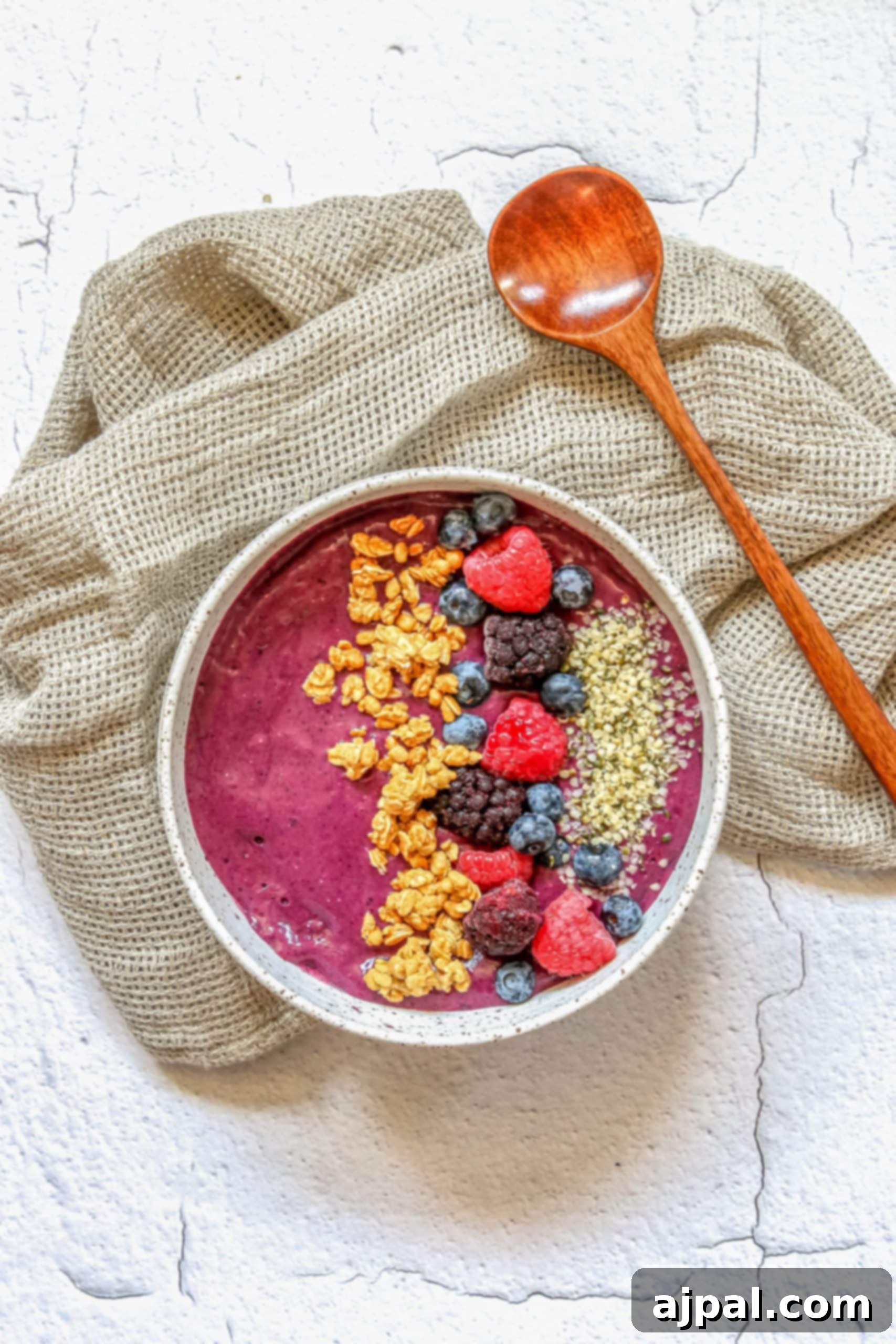 Triple Berry Smoothie Bowls 10 A stunning triple berry smoothie bowl, elegantly garnished with fresh raspberries, blueberries, granola, and hemp hearts, poised for enjoyment.