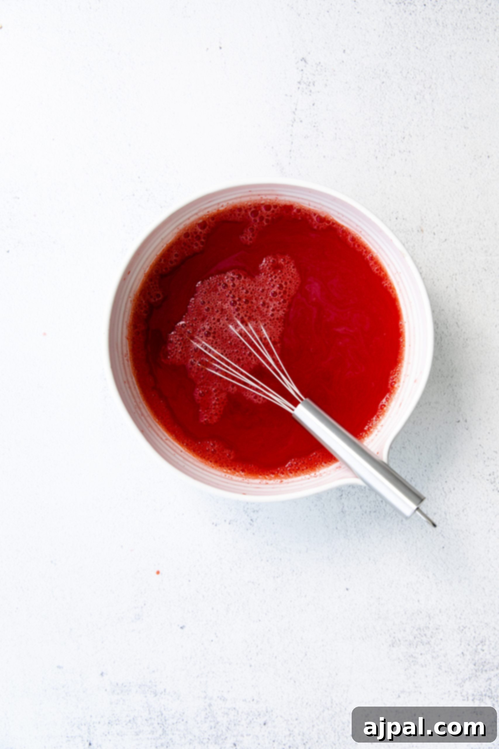 Star-Spangled Jello Cups 7 A bowl of red sauce with a whisk in it, perfect for a Fourth of July celebration.