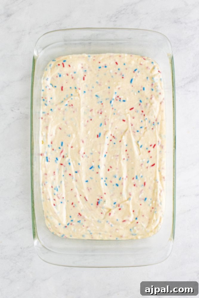 red white and blue funfetti cake batter in a cake pan