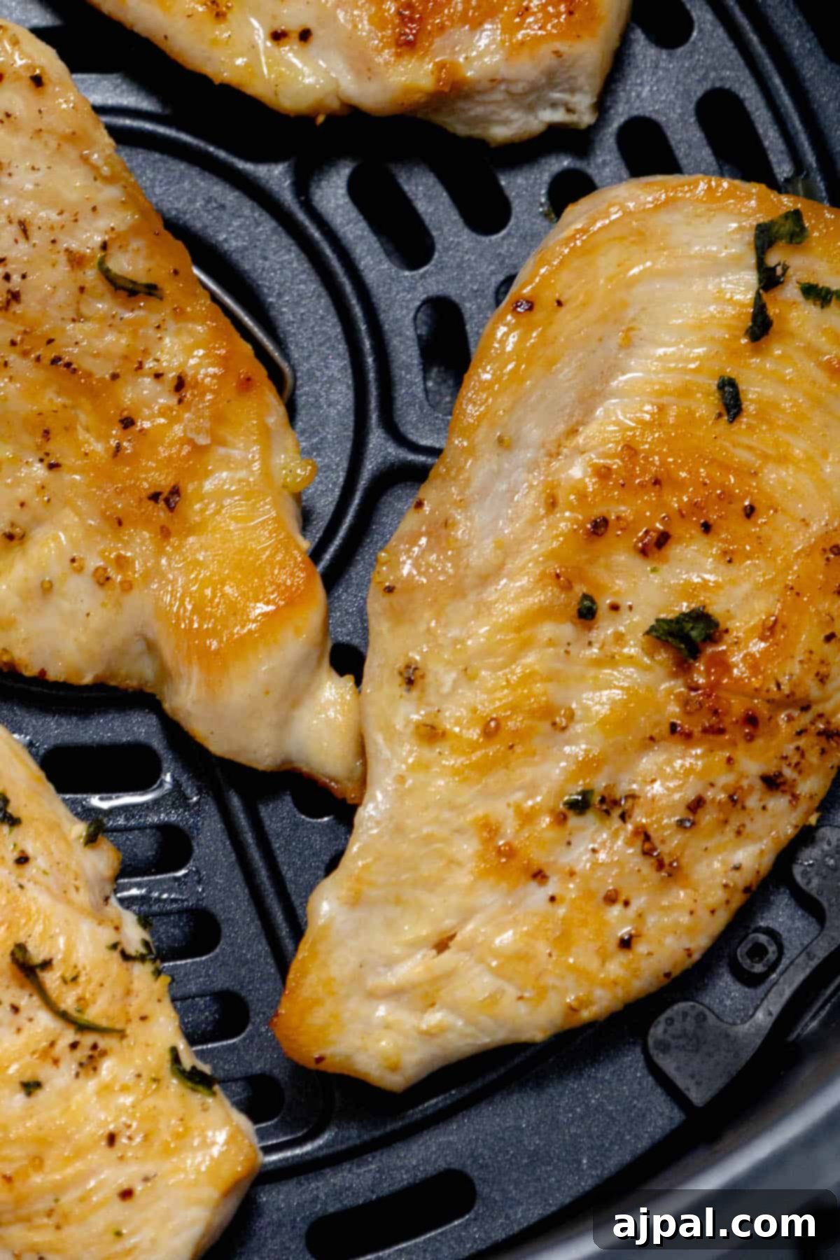 Air fried chicken breasts in an air fryer, showcasing the crispy exterior.