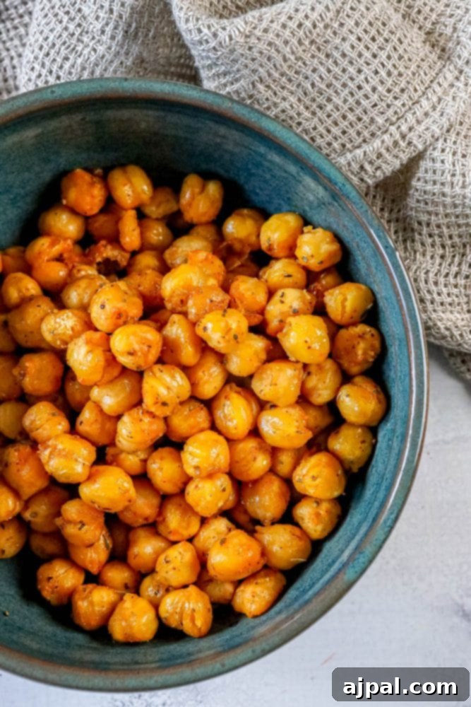 Zesty Air Fried Chickpea Crunch 4 Air fried chickpeas coated in lemon pepper seasoning in a blue bowl.