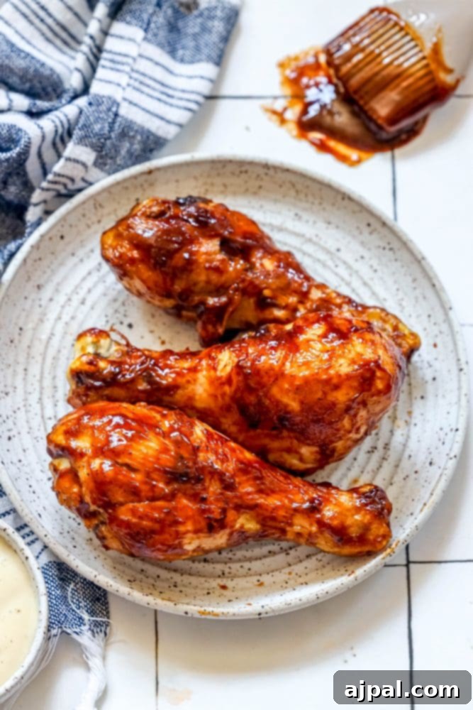 Ultimate Crispy Air Fryer BBQ Drumsticks 2 Delicious air fried BBQ chicken drumsticks on a white plate, glistening with rich barbecue sauce