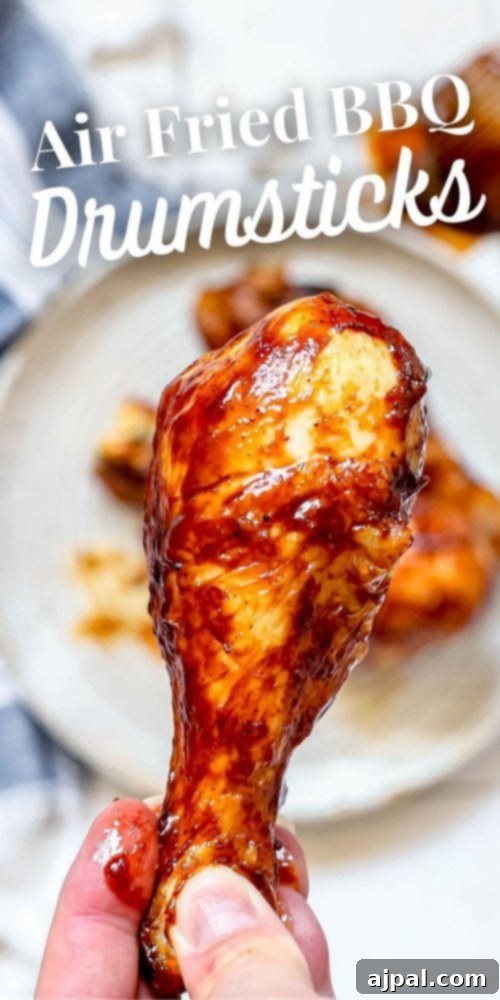 Ultimate Crispy Air Fryer BBQ Drumsticks 7 hand holding chicken drumstick with bbq chicken