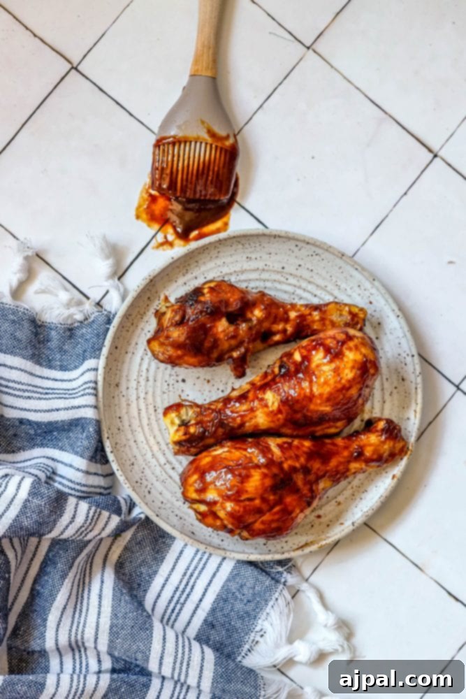 Ultimate Crispy Air Fryer BBQ Drumsticks 5 Air fried BBQ chicken drumsticks on a white plate, ready to be served